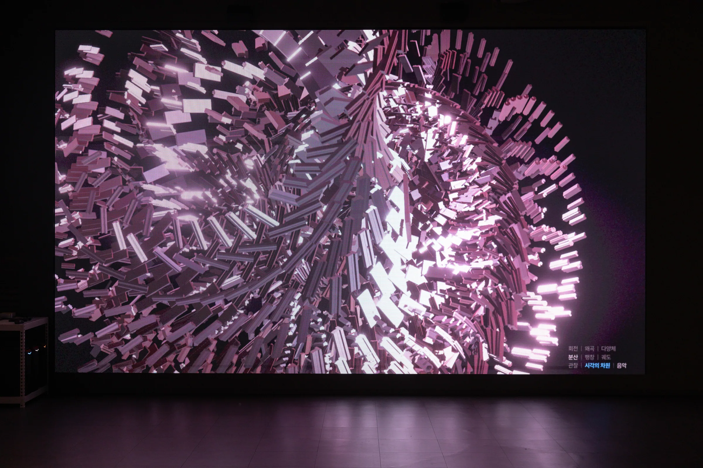 Jeanyoon Choi, ∫ (Banpo-Xism) (2026) — the apartment grid spinning across the media wall in a pink-violet wash. Tapping an advertisement integrates the plane outward into a manifold.